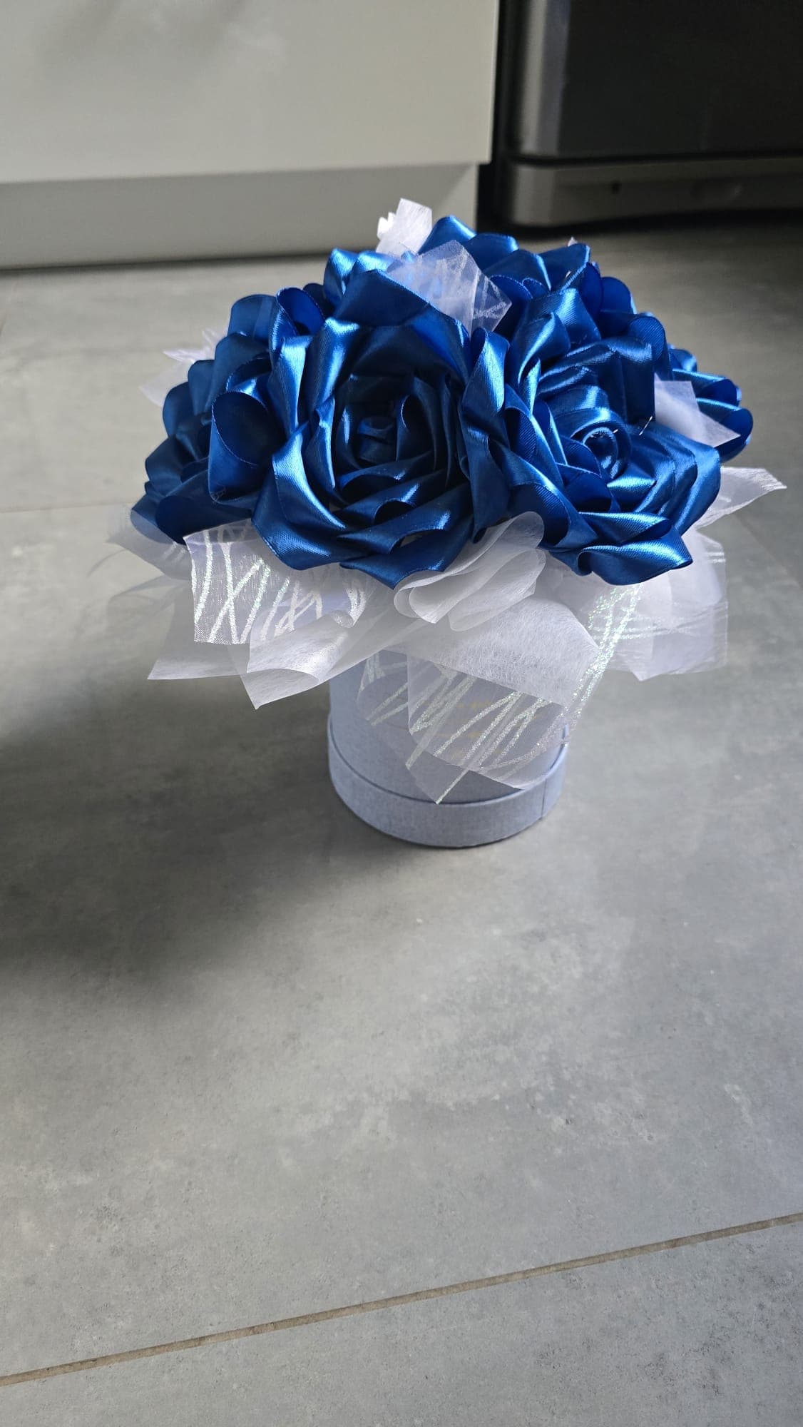 Zbliżenie kobaltowych róż ze wstążek satynowych w jasnym flower boxie